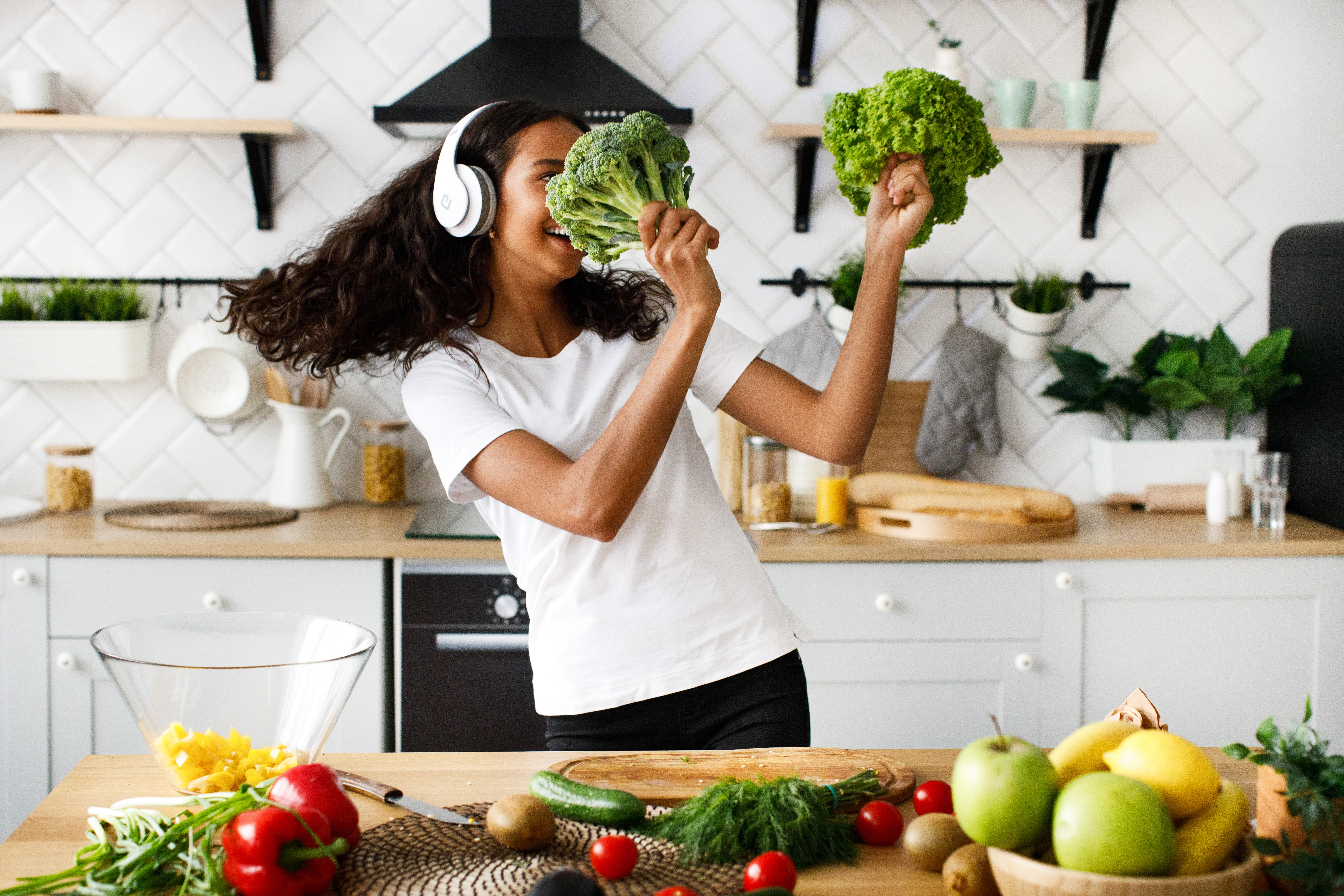 Woman joyfully cooking with fresh vegetables